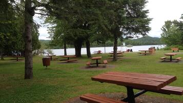 Sit and enjoy the serene lakeside views from one of our picnic tables, surrounded by a tranquil forest and a calm lake.