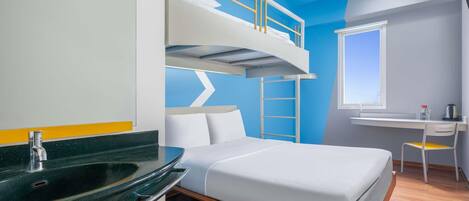 A bunk bed room with a desk and a window.