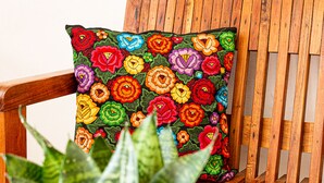 A wooden chair with a colorful floral cushion. - Hotel Casa Hipil (Valladolid)