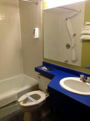 A bathroom with a bathtub, toilet, and sink.