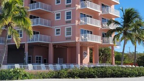 A multi-story hotel with balconies, a sandy beach in front, and palm trees. - Edison Beach House (Fort Myers Beach)
