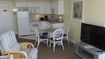 A compact living space with a kitchenette, dining area, and seating.