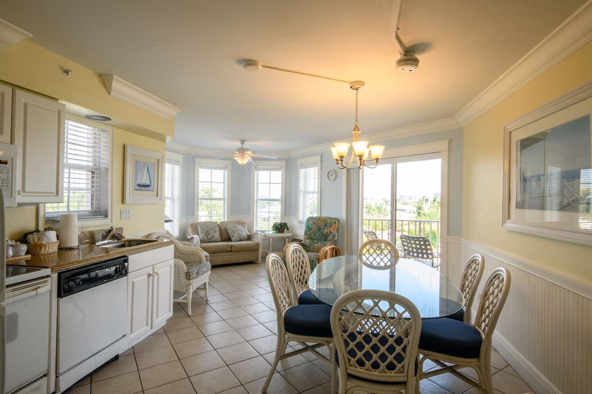 A spacious kitchen with a dining area, a ceiling fan, and a view of the outdoors.