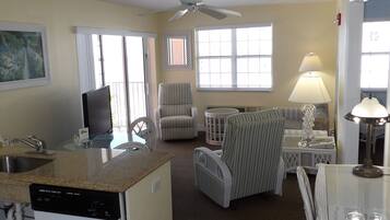 A compact living space with a kitchenette, a dining area, and a seating area with a ceiling fan.