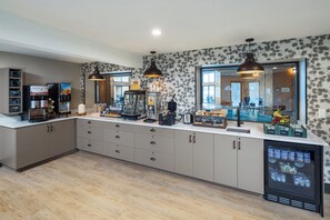 Eine moderne Küche mit Kaffeemaschine, Kühlschrank und Arbeitsfläche.
