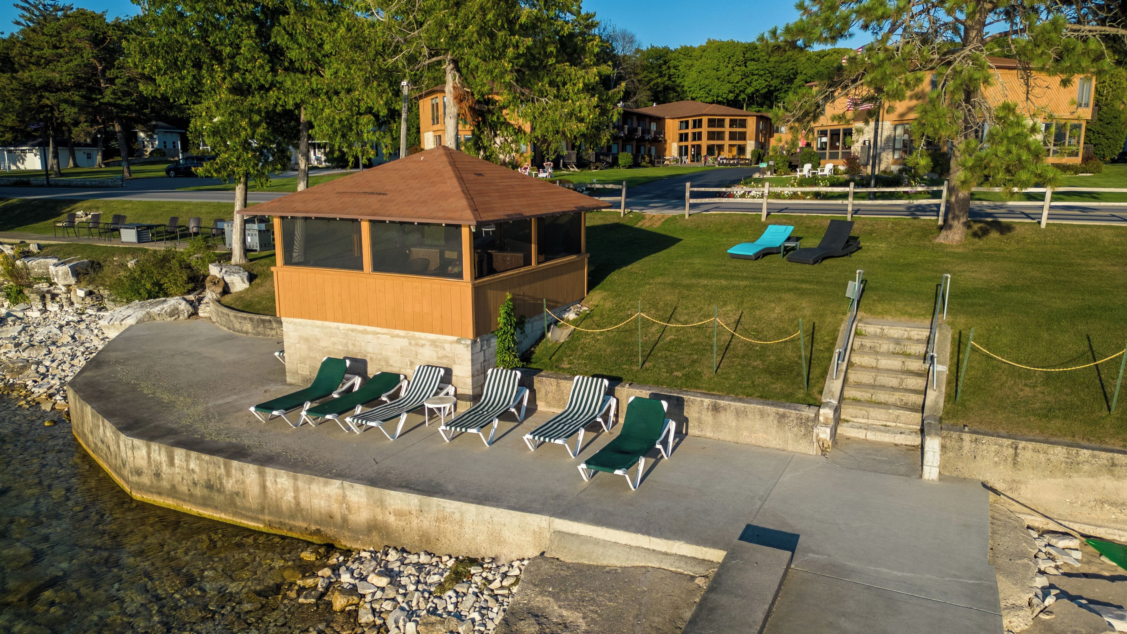 A gazebo with a roof, surrounded by lounge chairs and a small pool area.