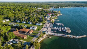 An aerial view of a coastal town with a marina, houses, and a forested area. - Pine Grove Resort (Ephraim)