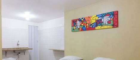 Una habitación de hotel con dos camas, ducha y lavamanos.