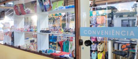 Un negozio con scaffali pieni di giocattoli e abbigliamento colorati per bambini.