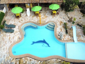 A swimming pool with a dolphin mural, surrounded by lounge chairs and umbrellas. - Pousada Jardins do Porto (Ipojuca)
