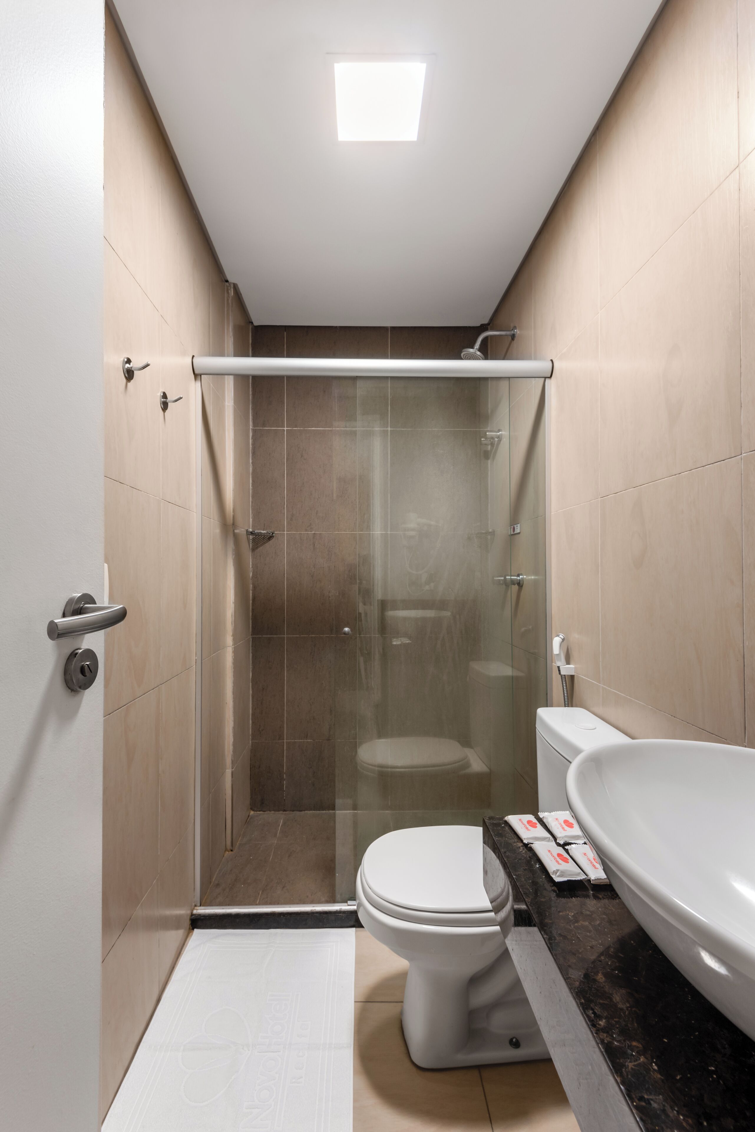 Une salle de bain moderne avec une douche à parois de verre, des toilettes et un grand lavabo.