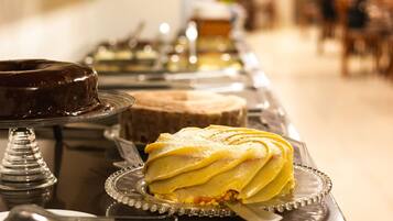Ein Buffet mit verschiedenen Speisen, darunter Schokoladenkuchen, eine Schichttorte und Sandwiches.