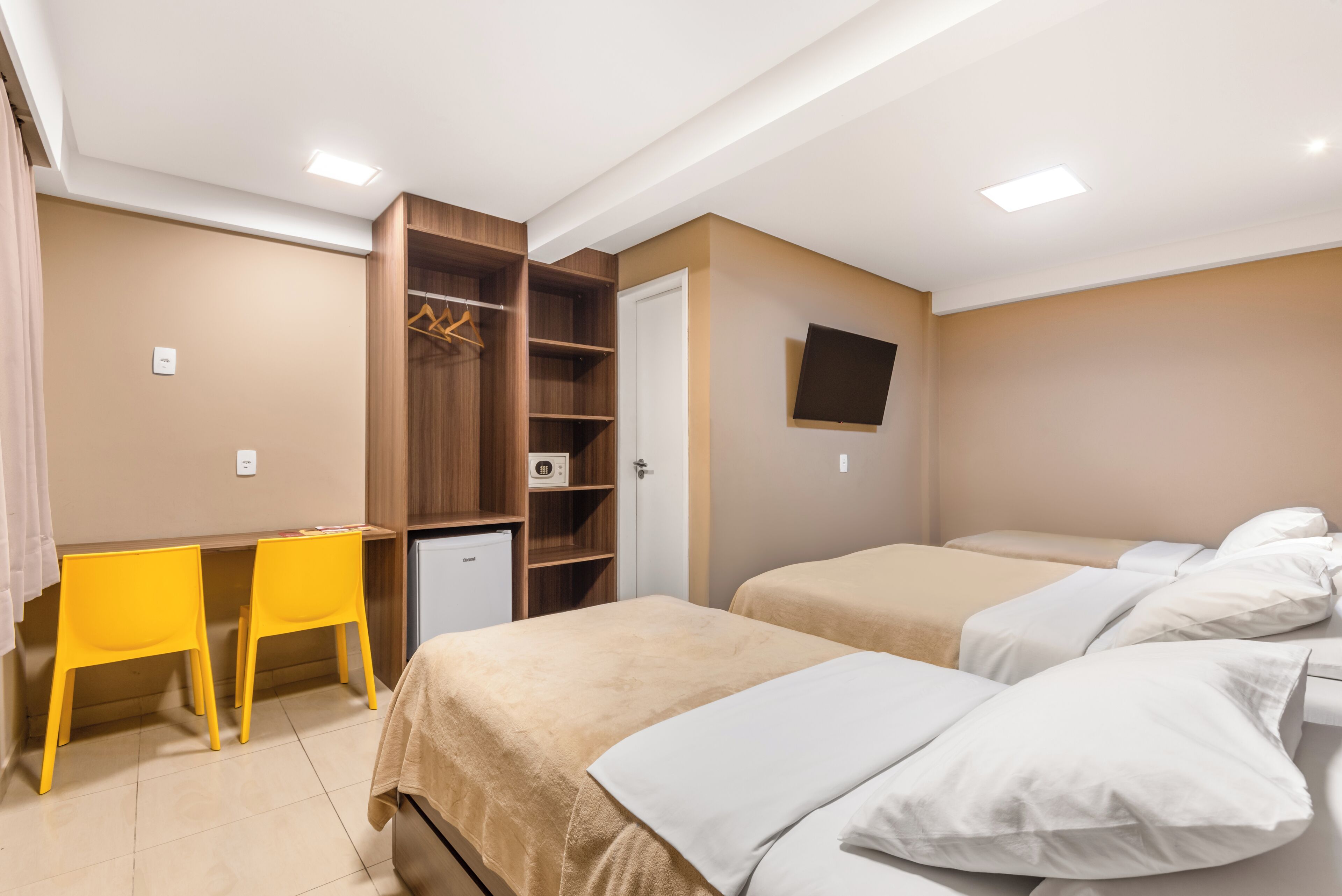 Una camera da letto con due letti, una scrivania e un armadio.