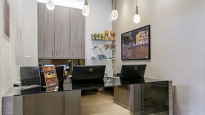 A modern office space with glass desks, two laptops, and a framed cityscape picture on the wall. - VilaHotell Recife (Recife)