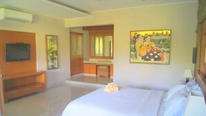 Une chambre d’hôtel avec un grand lit, un bureau avec une chaise, une télévision et un tableau au mur.