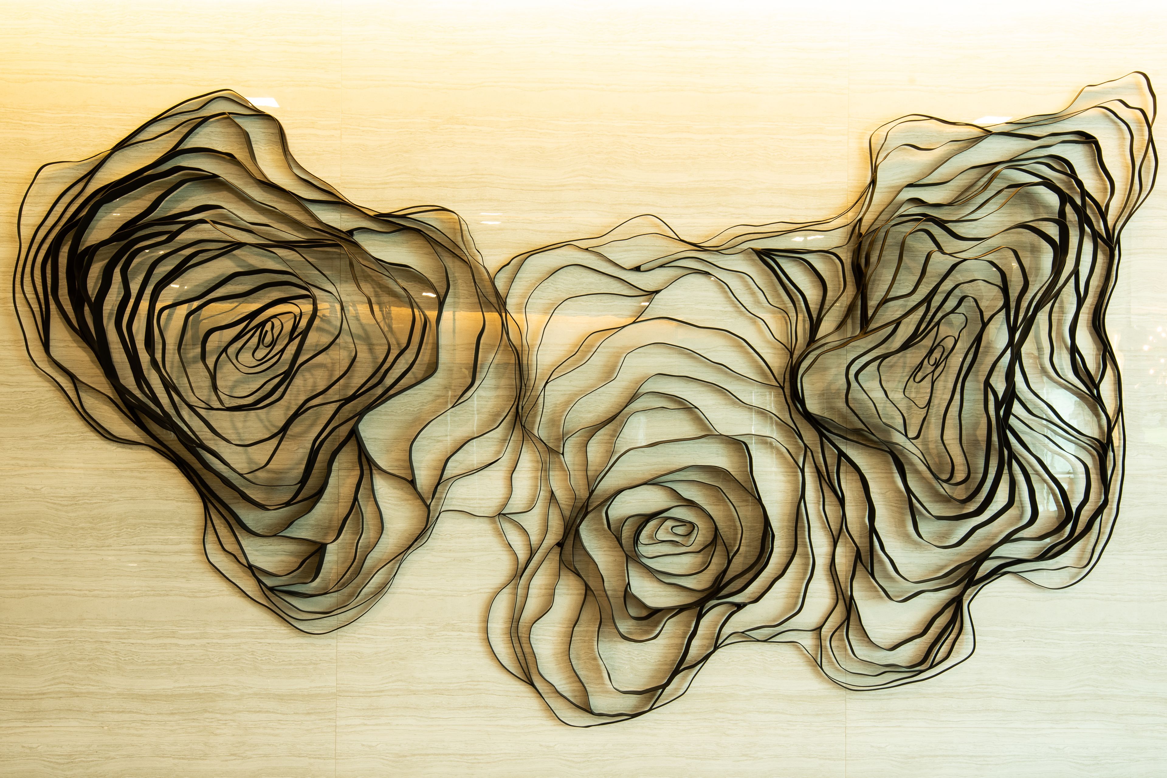 A wall with abstract art featuring layered, swirling patterns.