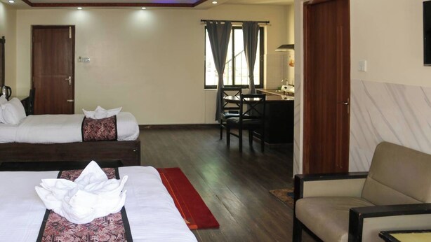 A hotel room with two beds, a desk, and a chair. - Apartment Hotel 11 Thamel (Kathmandu)