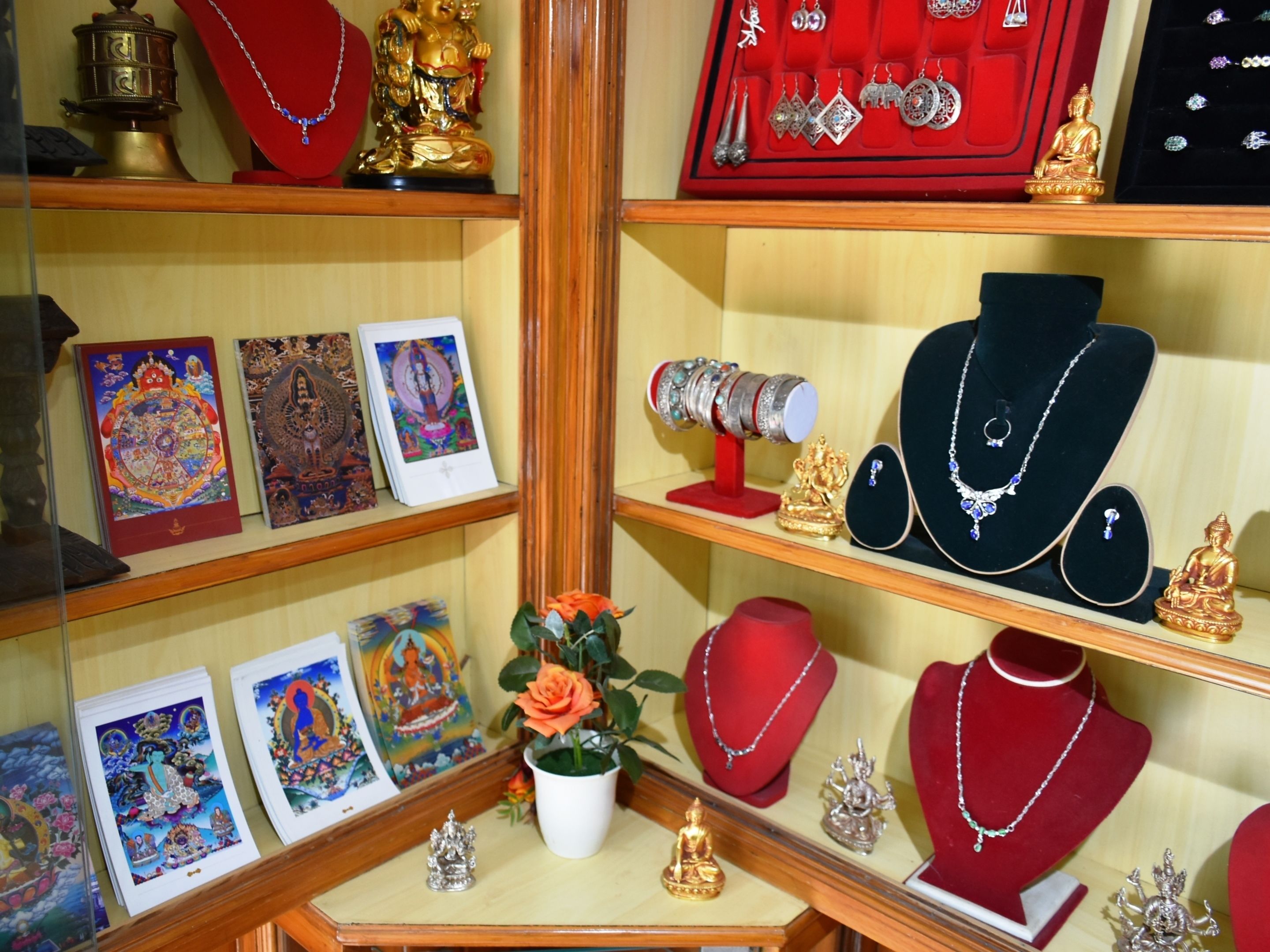 A jewelry display with various items including necklaces, earrings, and a Buddha statue.