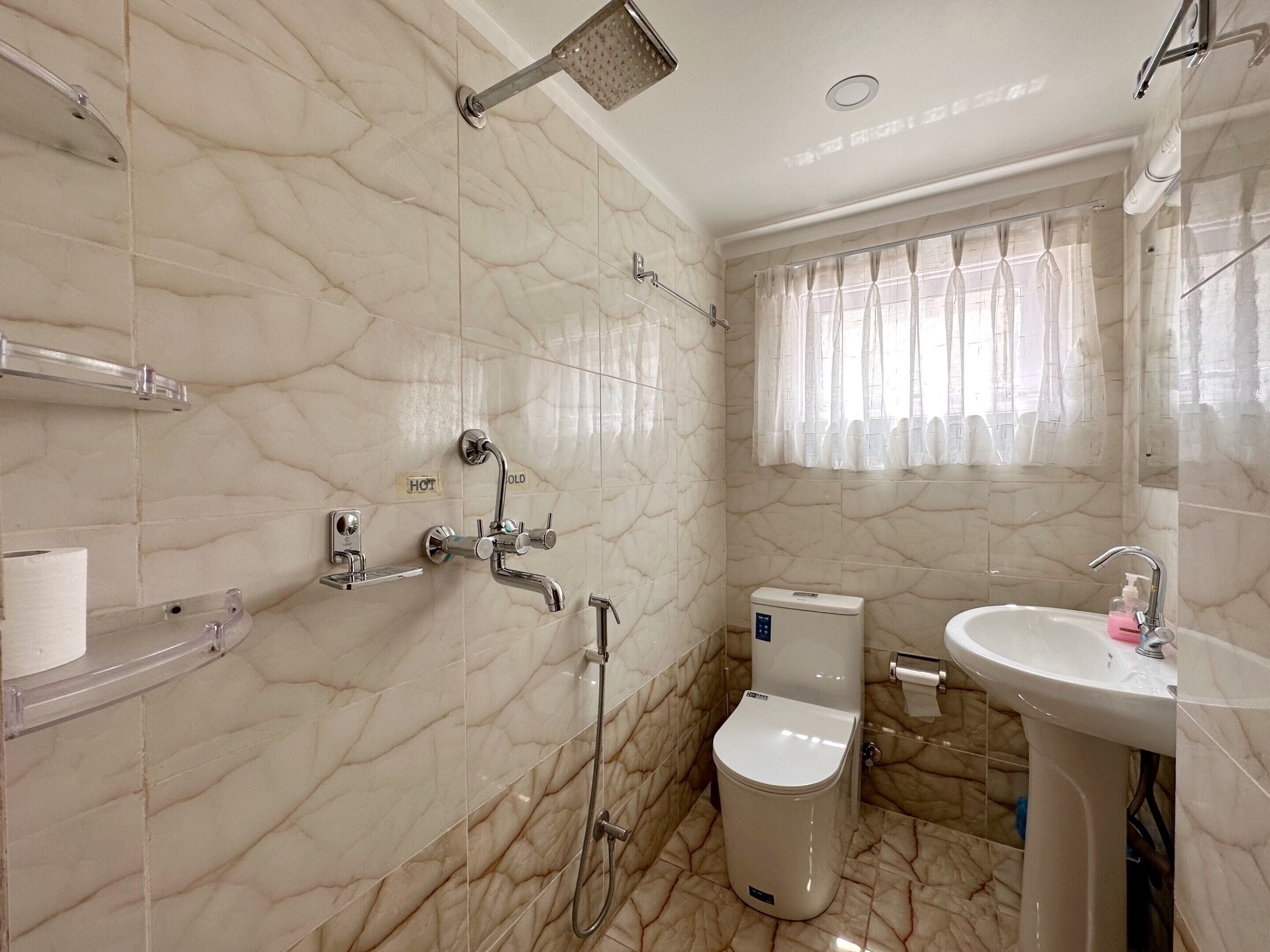 Un baño con ducha, inodoro y lavamanos.
