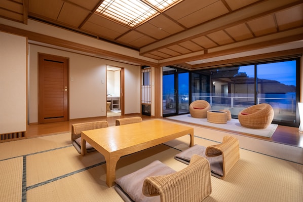 A traditional Japanese-style room with tatami flooring, a wooden table, and woven chairs.