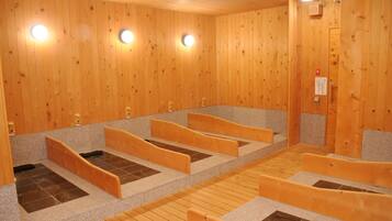 A sauna room with wooden walls, multiple benches, and built-in benches.
