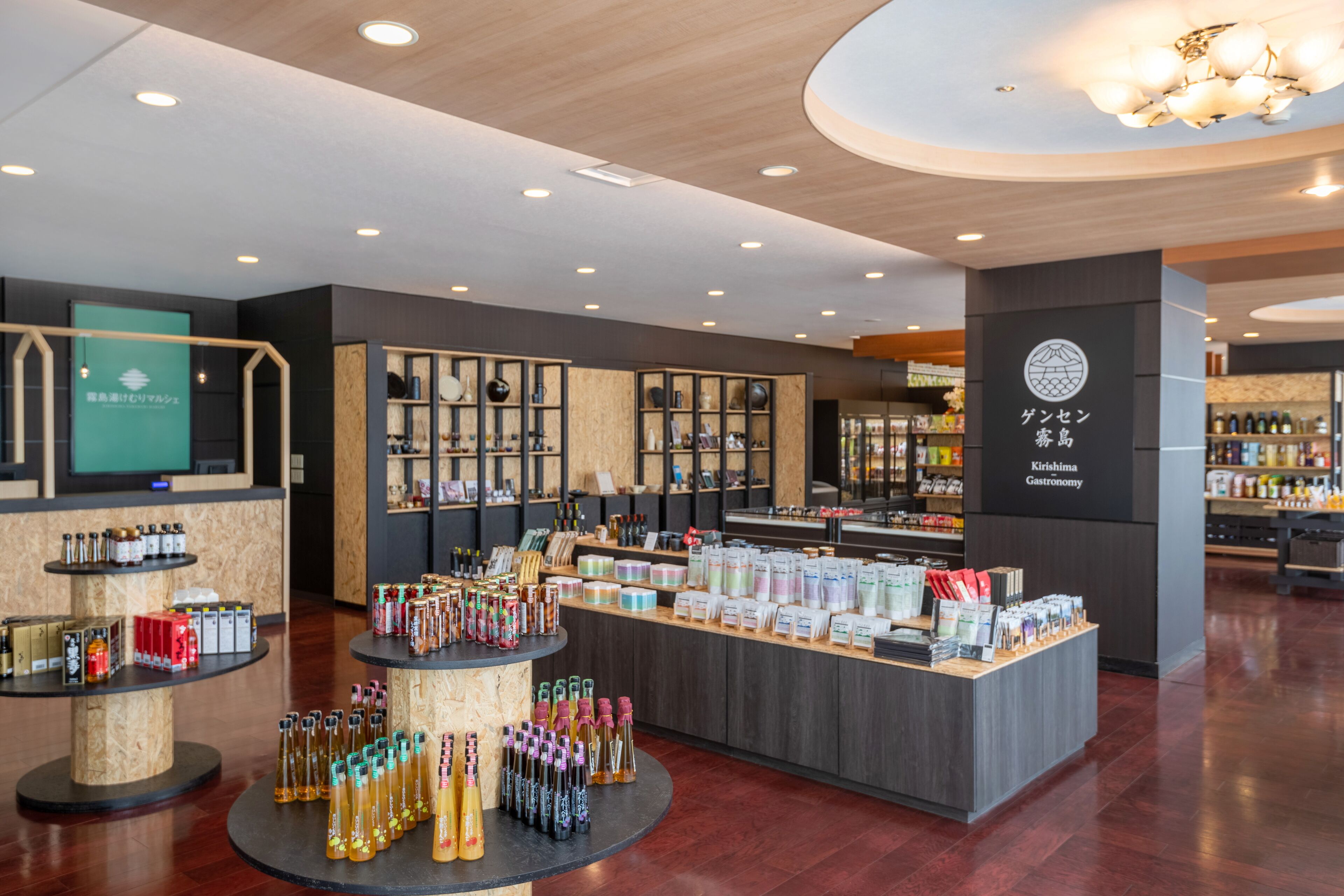 A modern retail space with wooden flooring, a central display counter, and various products on shelves.