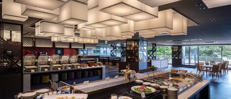 Un comedor moderno de hotel con barra libre, ventanas amplias y vistas al exterior.