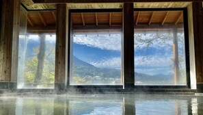 A room with large windows, wooden beams, and a reflective floor. - Musashino Bekkan (Hakone)