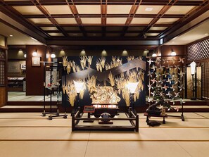 A traditional Japanese room with tatami flooring, a shoji screen, and a display of cultural artifacts. - Musashino Bekkan (Hakone)