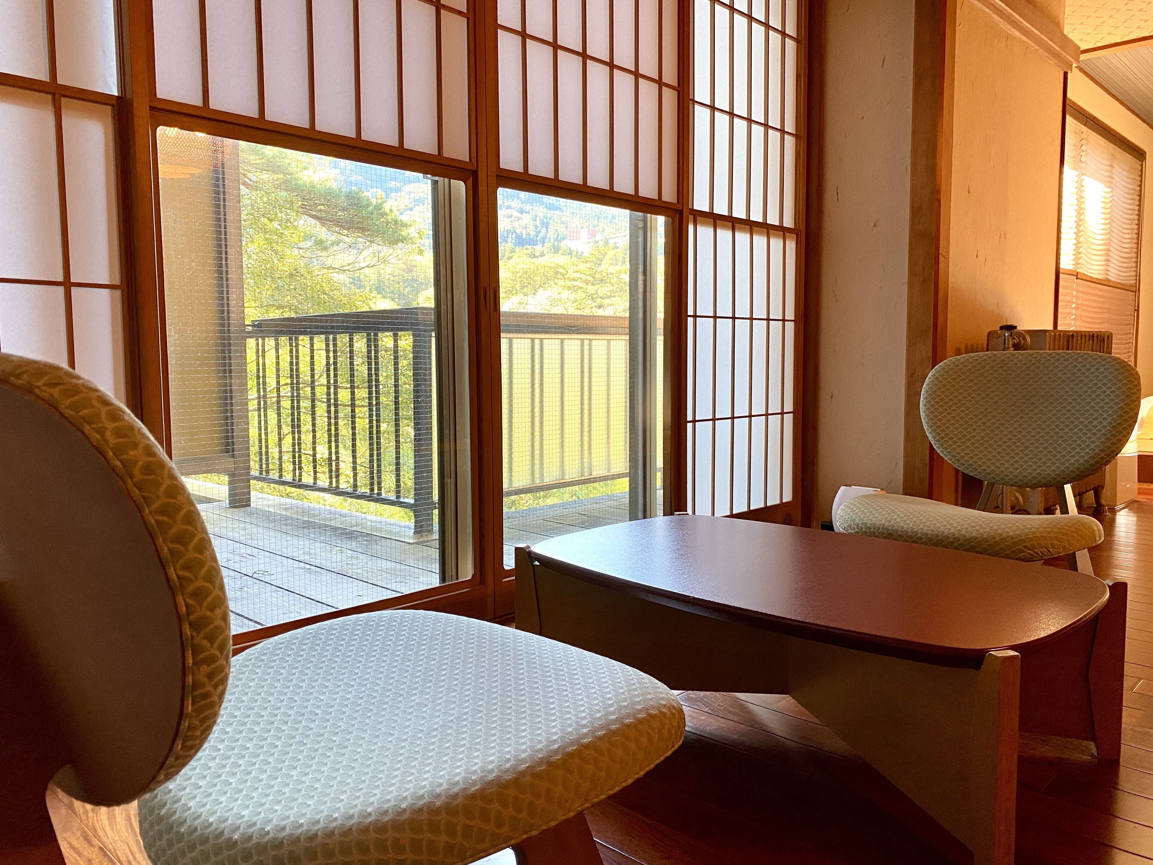 Ein traditioneller japanischer Raum mit Tatami-Bodenbelag, einem niedrigen Holztisch und zwei Tatami-Sitzmatten.