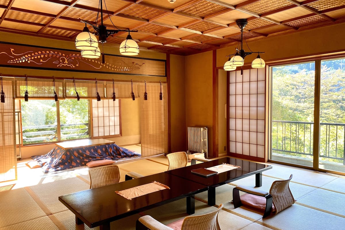 A traditional Japanese-style room with tatami flooring, a low table, and shoji screens.