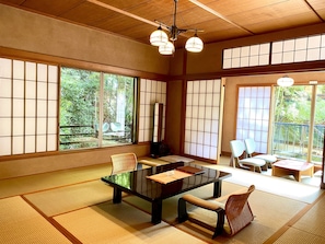 A traditional Japanese room with tatami flooring, a low table, and shoji screens. - Musashino Bekkan (Hakone)