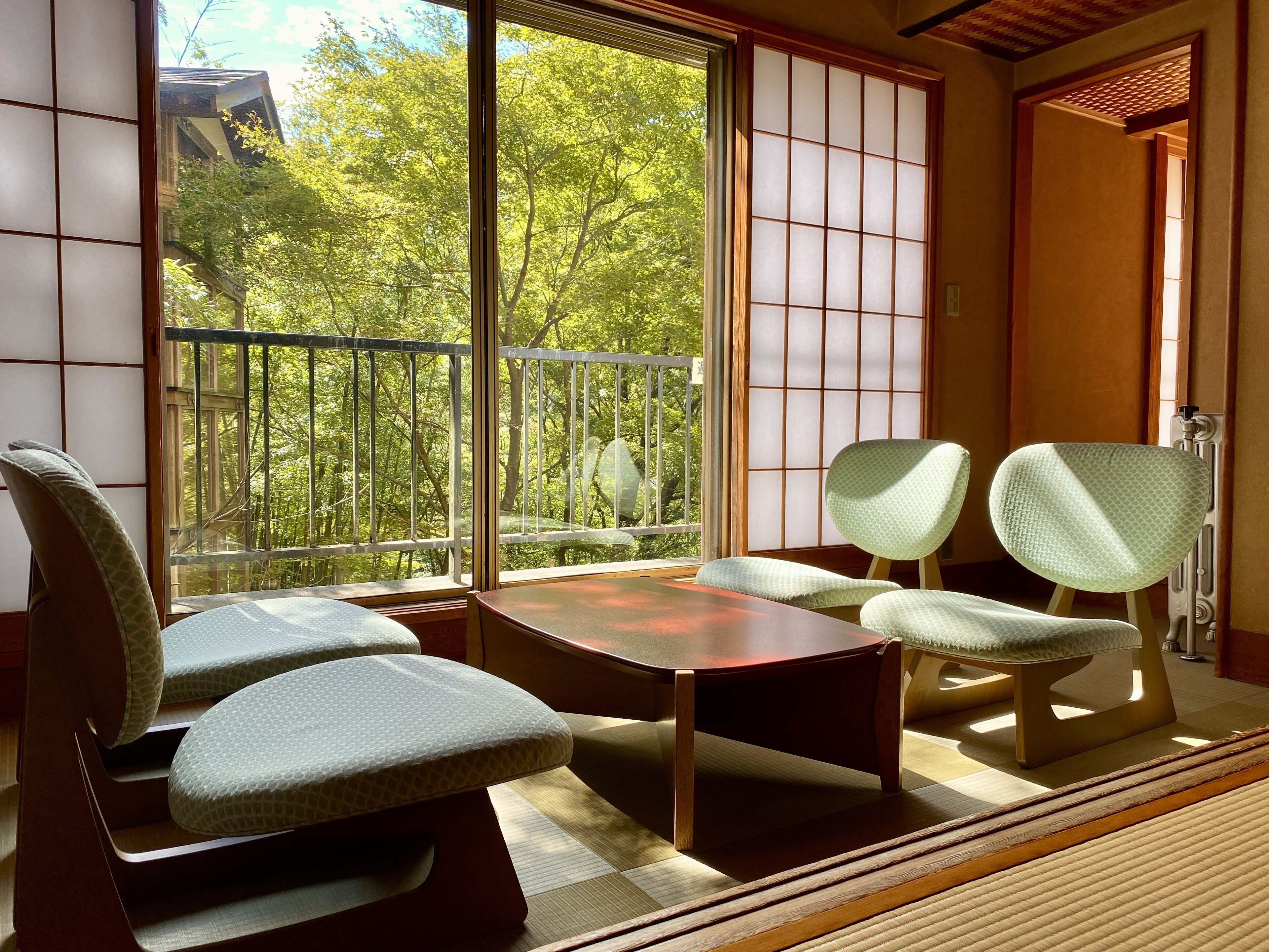 A traditional Japanese room with tatami flooring, a low table, and shoji screens.