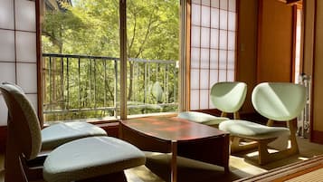 Una habitación japonesa tradicional con suelo de tatami, una mesa baja y paneles shoji.