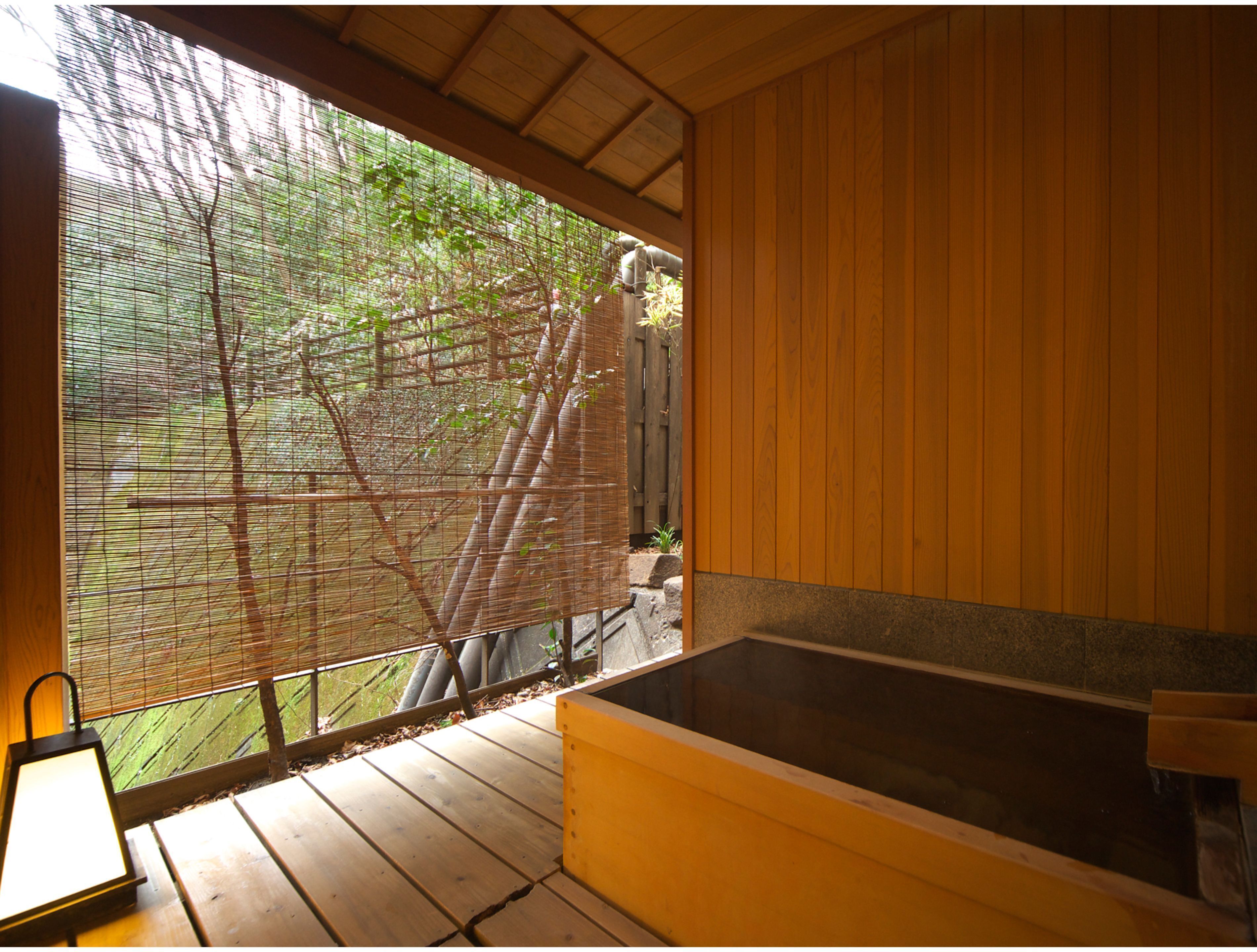 A wooden cabin with a large window overlooking a garden.