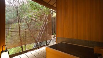 A wooden cabin with a large window overlooking a garden.