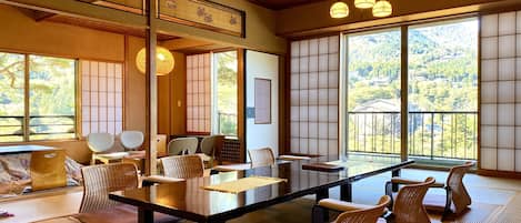 Quarto em estilo japonês tradicional, com tatames, uma mesa baixa e biombos shoji.