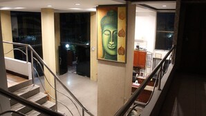 Una escalera con barandillas de metal que lleva a una habitación con un cuadro de Buda en la pared.