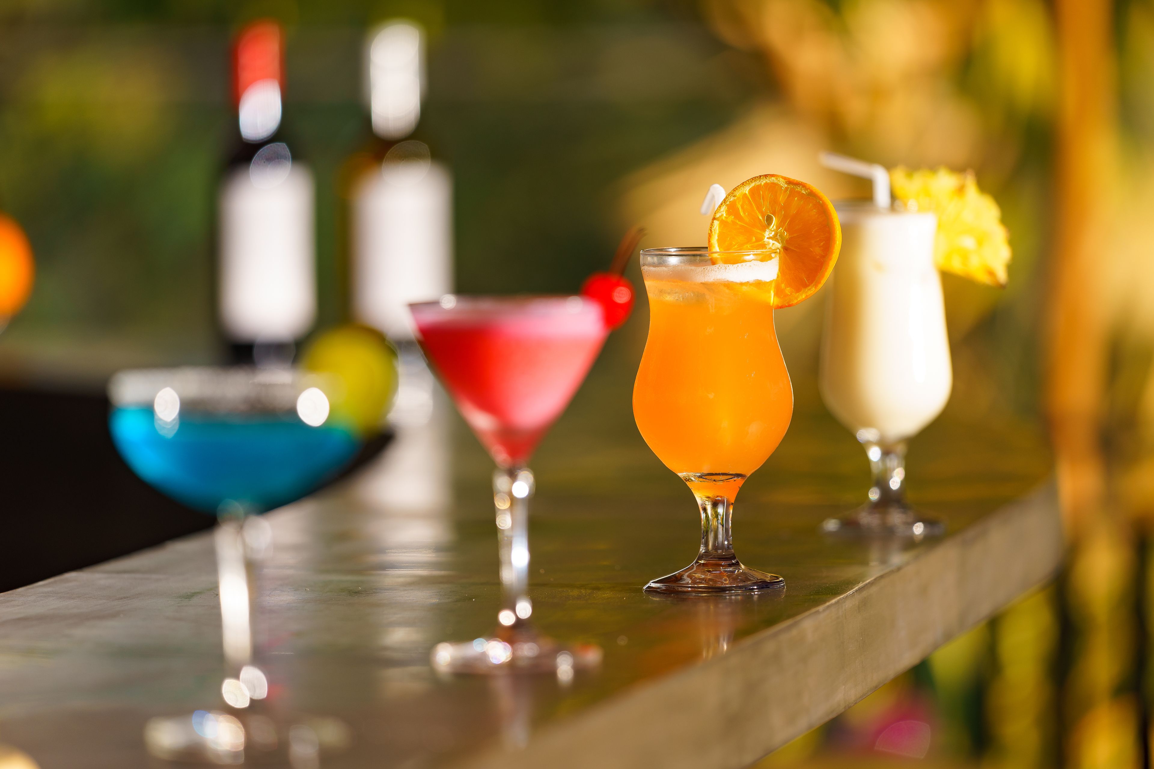 Un bar proposant une variété de cocktails colorés et de bouteilles.