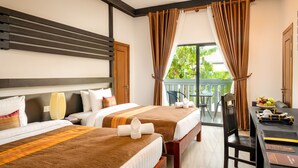 Quarto de hotel com duas camas, varanda, mesa de jantar e vista para áreas verdes.
