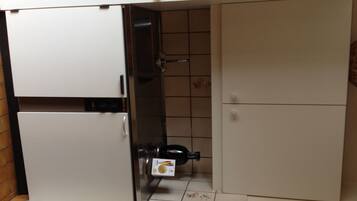 A compact kitchen with a built-in refrigerator, a microwave, and a sink.