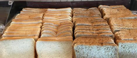 A display of various types of bread in a bakery.