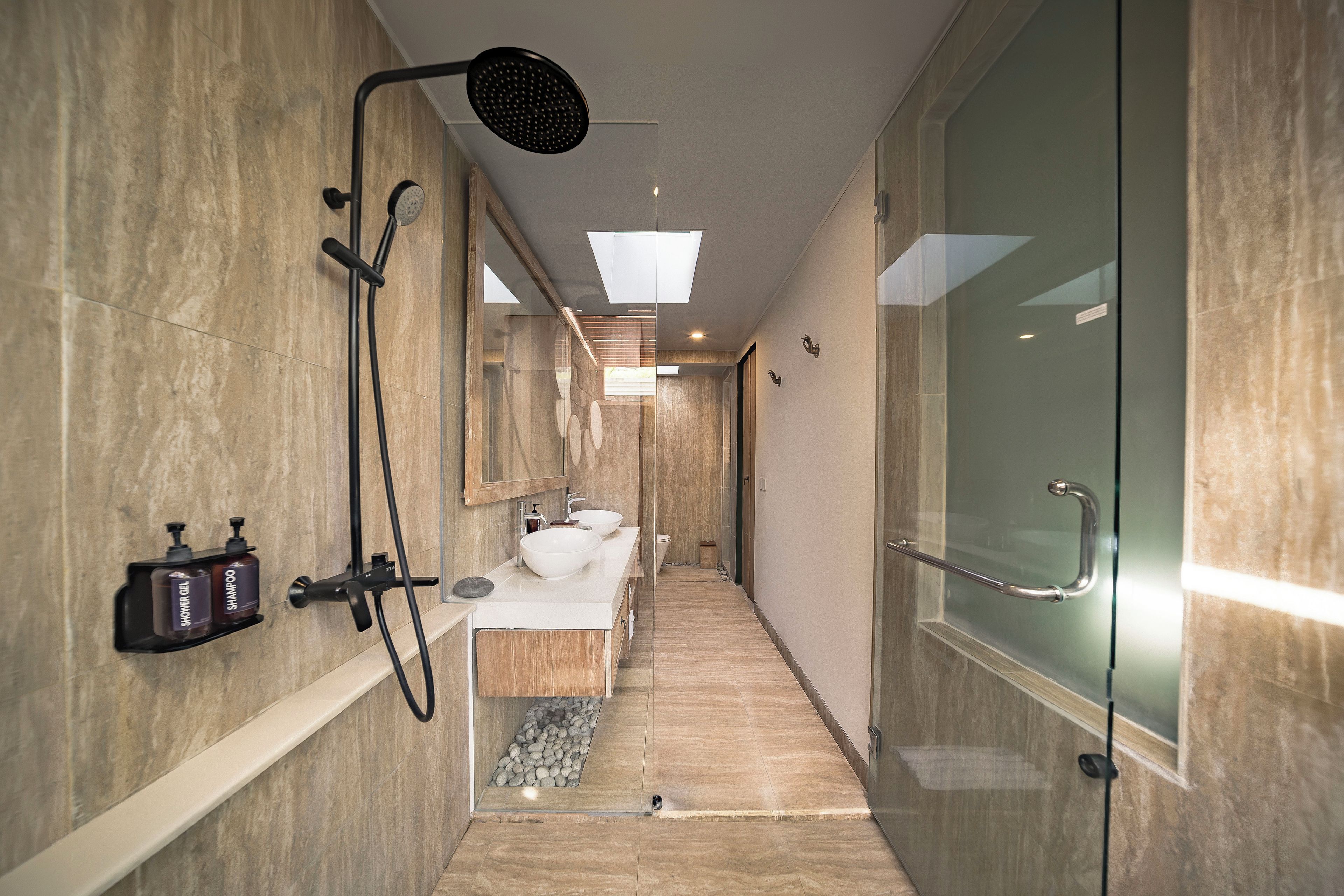 A modern bathroom with a shower, a sink, and a glass shower door.