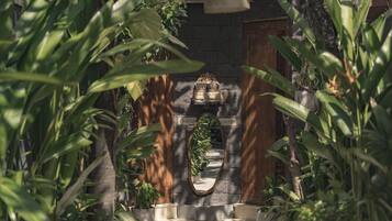 A stone archway with a wooden door, surrounded by lush greenery.