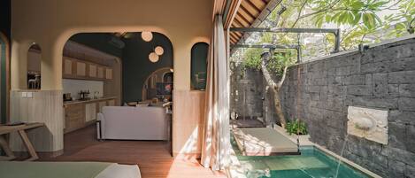 A modern interior with a kitchen, dining area, and a small pool area.