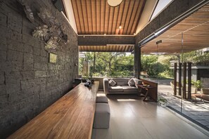 Un interno moderno con una panca in legno, un divano e un muro in pietra.