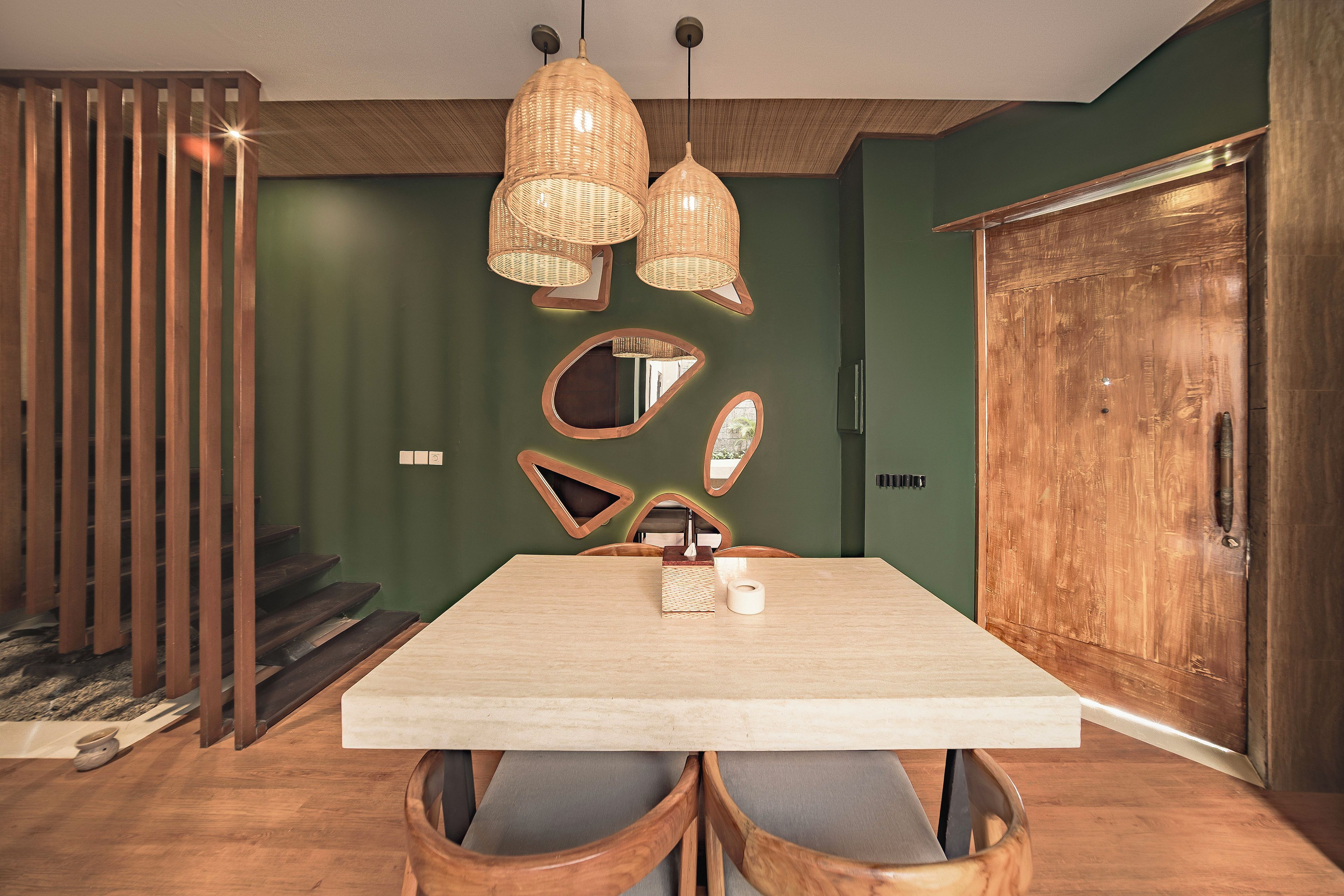 A dining area with a wooden table, chairs, and a large mirror on the wall.