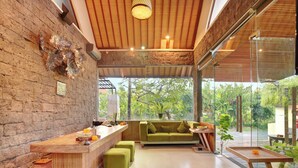 Un interior moderno con pared de piedra, techo de madera y sofá verde.