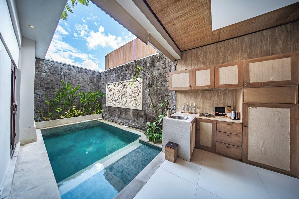 A modern kitchen with a built-in sink, wooden cabinets, and a stone accent wall.