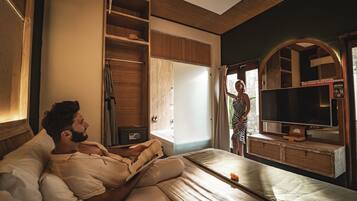A bedroom with a bed, a television, and a wardrobe.